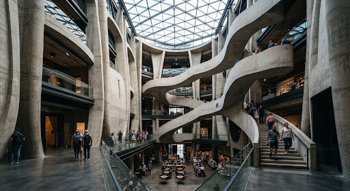 Interior architecture with a sweeping staircase under a glazed roof.