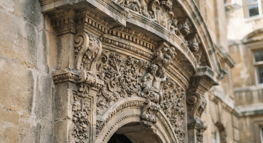 Close-up of classical stone carving on a historic building facade, showing floral and architectural motifs.